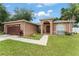 Charming single-story home featuring an arched entryway, lush lawn, and attached garage at 470 Cardinal Ct, Kissimmee, FL 34759