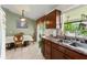 Traditional kitchen with wooden cabinets, tile floors, double basin sink, and a view to the outside at 470 Cardinal Ct, Kissimmee, FL 34759