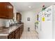 Functional kitchen space with white appliances and dark wood cabinets and tiled floors at 470 Cardinal Ct, Kissimmee, FL 34759