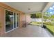 Covered patio with tiled floor, chair, and sliding glass doors overlooking the green backyard at 470 Cardinal Ct, Kissimmee, FL 34759