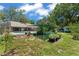 Backyard with lush landscaping, an in-ground pool, covered patio, and cultivated garden at 473 Burnt Tree Ln, Apopka, FL 32712