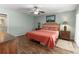 Comfortable bedroom features wood flooring, a ceiling fan, and a tranquil color scheme at 473 Burnt Tree Ln, Apopka, FL 32712