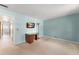 Bright bedroom with light-blue walls, a TV, an antique lamp, and a desk with view into bathroom at 473 Burnt Tree Ln, Apopka, FL 32712