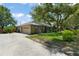 Charming brick home with mature trees, a well-manicured lawn, and a long concrete driveway at 473 Burnt Tree Ln, Apopka, FL 32712