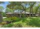 Charming brick home featuring a lush, green lawn and mature trees providing ample shade at 473 Burnt Tree Ln, Apopka, FL 32712
