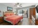 Charming main bedroom featuring wood look floors and sliding glass doors leading to the lanai and pool area at 473 Burnt Tree Ln, Apopka, FL 32712