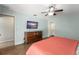 Comfortable main bedroom with warm wood floors, light blue walls, and a ceiling fan with a light kit at 473 Burnt Tree Ln, Apopka, FL 32712