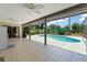 Covered patio with tile flooring, ceiling fan and view of the beautiful in-ground pool and backyard at 473 Burnt Tree Ln, Apopka, FL 32712