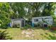 Two storage sheds in the backyard surrounded by lush landscaping and mature trees at 473 Burnt Tree Ln, Apopka, FL 32712