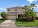 Charming two-story home with a well-maintained lawn and beautiful tropical landscaping at 512 Bella Rosa Cir, Sanford, FL 32771