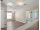 Upstairs loft with wood-look floors and two open doorways to other rooms at 512 Bella Rosa Cir, Sanford, FL 32771