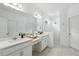 Bright bathroom with double vanity, white cabinets, quartz countertops, and walk-in glass shower at 5314 Golden Apple Dr, Winter Garden, FL 34787