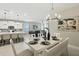 Open concept dining room leading into kitchen with table seating for six with white accents and beachy decor at 5314 Golden Apple Dr, Winter Garden, FL 34787