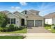 Charming single-Gathering home featuring a two-car garage, brick driveway, and beautifully landscaped front yard at 5314 Golden Apple Dr, Winter Garden, FL 34787
