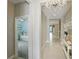 Bright hallway with tile flooring, chandelier lighting, and entry view into a bedroom with a ceiling fan at 5314 Golden Apple Dr, Winter Garden, FL 34787