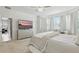 Bright main bedroom featuring a large bed, dresser with TV, and comfortable seating area at 5314 Golden Apple Dr, Winter Garden, FL 34787