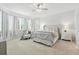 Bright main bedroom with neutral color palette, tray ceiling, seating area, and plush carpeting at 5314 Golden Apple Dr, Winter Garden, FL 34787