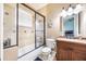 Well-lit bathroom offers a shower-tub combo with a glass door, providing a functional and stylish design at 5413 Via Veneto Ct, Sanford, FL 32771