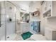 Bright bathroom with a glass shower, white vanity, and gray tile flooring, offering a clean and modern space at 5413 Via Veneto Ct, Sanford, FL 32771