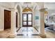 Elegant foyer featuring tile floors, decorative columns, arched doorways, and a stylish light fixture at 5413 Via Veneto Ct, Sanford, FL 32771