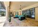 Covered patio features stone floors, a modern fan, TV, and a comfortable wicker sofa at 5413 Via Veneto Ct, Sanford, FL 32771