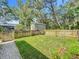 View of the backyard featuring a green lawn surrounded by a wooden fence and mature trees at 5489 Glen Oak Place, Sanford, FL 32771