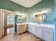 Well-lit bathroom featuring double sinks and stylish light fixtures at 5489 Glen Oak Place, Sanford, FL 32771