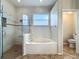 Bathroom features a tub, glass shower, and a tiled floor at 5489 Glen Oak Place, Sanford, FL 32771