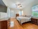 Bright bedroom with hardwood floors, ceiling fan, and plenty of natural light from two windows at 5489 Glen Oak Place, Sanford, FL 32771