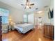 Cozy bedroom featuring hardwood floors, ceiling fan, and ample closet space at 5489 Glen Oak Place, Sanford, FL 32771
