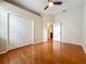 Empty bedroom with hardwood floors, ceiling fan, and large closet at 5489 Glen Oak Place, Sanford, FL 32771
