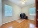 Bedroom with hardwood floors, ceiling fan, and large windows for natural light at 5489 Glen Oak Place, Sanford, FL 32771