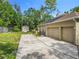 Side exterior view of a house featuring a two-car garage, shed, and driveway at 5489 Glen Oak Place, Sanford, FL 32771