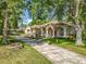 Stunning exterior view of the home with stucco, grand columns and mature trees at 5489 Glen Oak Place, Sanford, FL 32771