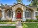 Charming home exterior with a red front door, arched entry and columns at 5489 Glen Oak Place, Sanford, FL 32771