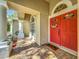 Tile front porch featuring a red double door with decorative wreath at 5489 Glen Oak Place, Sanford, FL 32771