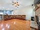 Large living room with hardwood floors, fireplace, and comfortable leather sectional sofa at 5489 Glen Oak Place, Sanford, FL 32771