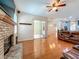 Spacious living room featuring a brick fireplace, ceiling fan, and sliding glass doors to the lanai at 5489 Glen Oak Place, Sanford, FL 32771
