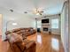 Living room featuring hardwood floors, natural light, a fireplace, ceiling fan and a large comfortable leather sofa at 5489 Glen Oak Place, Sanford, FL 32771