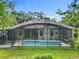 Back exterior view of a screened in pool and deck with the house and yard visible at 5489 Glen Oak Place, Sanford, FL 32771