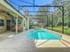 Backyard featuring a screened-in pool, lanai, ceiling fan, mounted TV, and lush landscaping at 5489 Glen Oak Place, Sanford, FL 32771