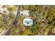 Overhead view of a community pool with a playground next to mature trees and a small pond at 654 Star Magnolia Dr, Kissimmee, FL 34744