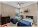 Comfortable bedroom with twin beds, ceiling fan, and natural light from the large window at 654 Star Magnolia Dr, Kissimmee, FL 34744