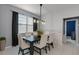 Dining room featuring a dark wood table, seating for six, modern lighting, and a large window at 654 Star Magnolia Dr, Kissimmee, FL 34744