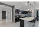 Modern kitchen featuring an island with barstool seating, stainless steel appliances, and sleek black cabinetry at 654 Star Magnolia Dr, Kissimmee, FL 34744