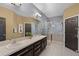 The main bathroom has a large mirror, double sinks, and a tiled shower with a glass enclosure at 654 Star Magnolia Dr, Kissimmee, FL 34744