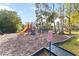 Community playground including a slide and other climbing equipment in a secure fenced area at 654 Star Magnolia Dr, Kissimmee, FL 34744