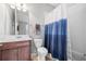 Bright bathroom featuring a shower with blue and white curtain, and a wood vanity with a white countertop at 661 Hangnest Ln, Lake Mary, FL 32746