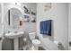 Modern bathroom features a pedestal sink, a toilet, and neutral decor, providing a clean and functional space at 661 Hangnest Ln, Lake Mary, FL 32746
