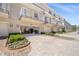 Townhome exterior featuring well-kept landscaping, brick paved driveway and attached garages under private balconies at 661 Hangnest Ln, Lake Mary, FL 32746